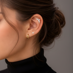 Model's ear styled with Lark & Berry's Crown Crawler diamond cartilage earring, a stud, and a gold hoop.