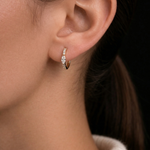 A model wears the gold Modernist Marquise Pave Hoop earring, featuring a central marquise diamond and pave details.
